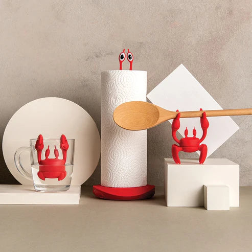Red crab-shaped kitchen tools on a neutral background